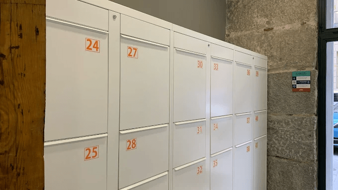 Consignas inteligentes de LookALocker en Madrid. Taquillas inteligentes Blancas con vinilos de numeración en color naranja.